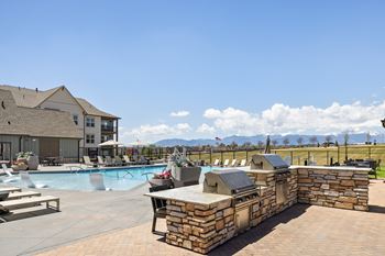 A large outdoor swimming pool with a stone wall and loungers.
