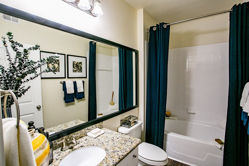 a bathroom with a white tub next to a sink and a toilet