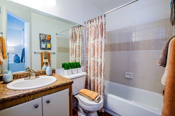 A bathroom with a toilet, sink, and bathtub.