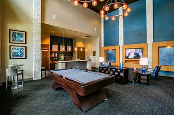 a pool table sits in the middle of a room with a bar