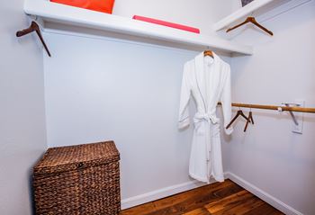A white robe is hanging on a rack in a room.