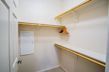 a walk in closet with a door and a mirror