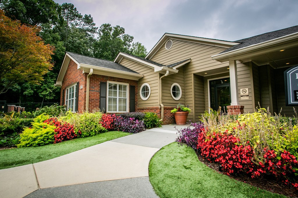 a house with a sidewalk in front of it and a garden