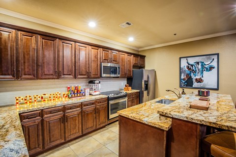 A kitchen with brown cabinets and a granite countertop.