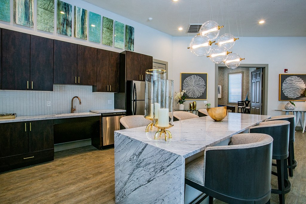 a kitchen with dark wood cabinets and a large island with a marble countertop