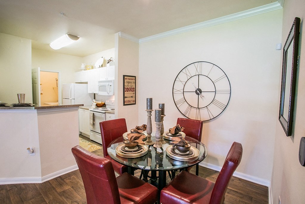 a dining room with a table and chairs and a large clock on the wall