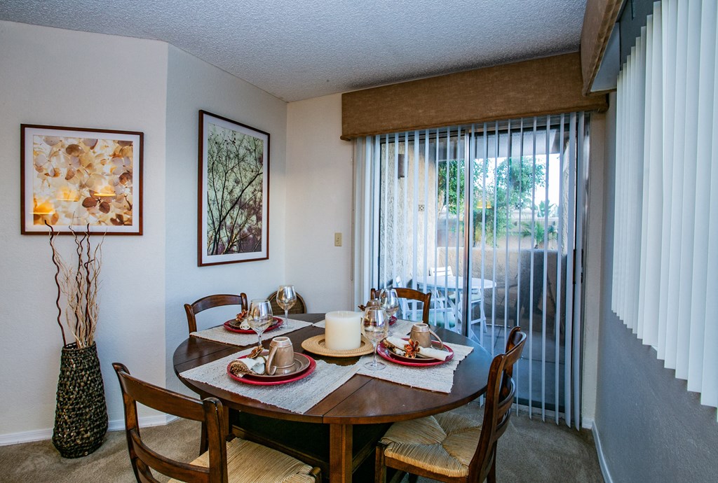 a dining room with a table and chairs and a sliding glass door