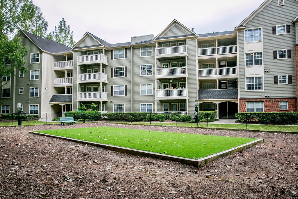 an exterior view of an apartment building with a green lawn