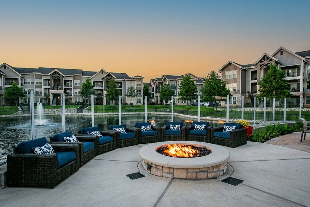 Cozy Firepit and Outdoor Lounge Seating by Lake at Houston Apartment Complex