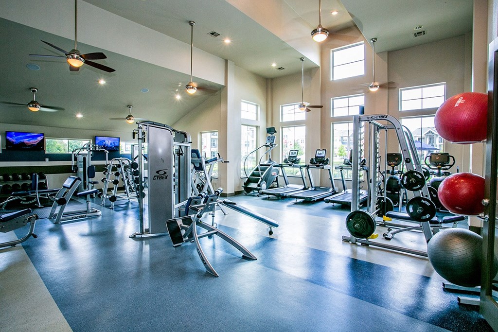 a large fitness room with cardio machines and other exercise equipment