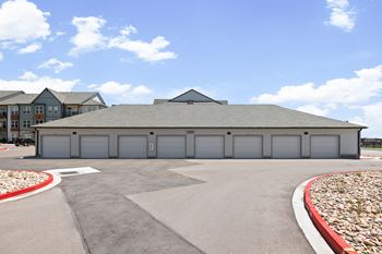 A large building with a grey roof and grey garage doors.