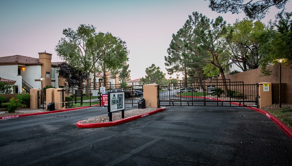 a parking lot in front of a building with a gate