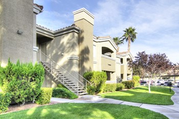 Outside view of two story apartment community building with green grass in the desert - Photo Gallery 15