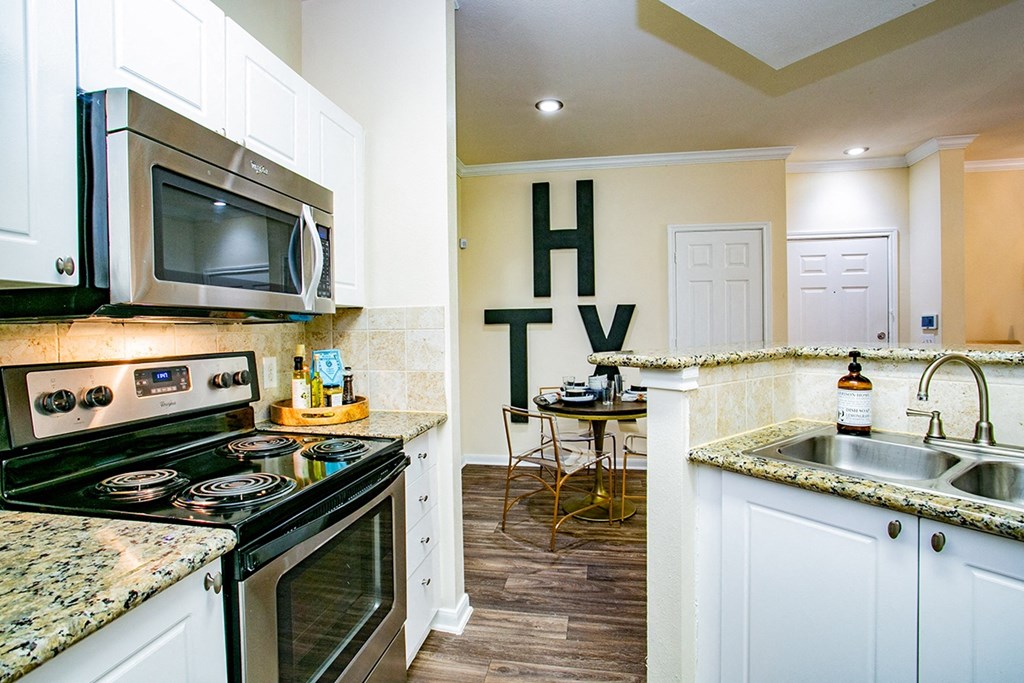 a kitchen with white cabinets and a stainless steel sink