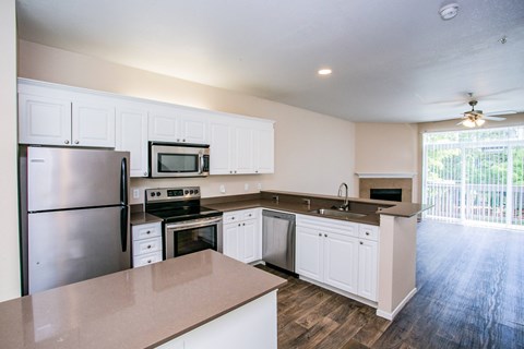 Spacious Model Living Room with Faux Wood Floors and Brick Wood-Burning Fireplace in Orenco Station Apartment