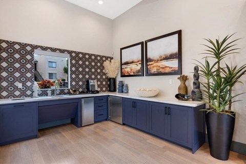 a blue and white kitchen with a sink and a mirror