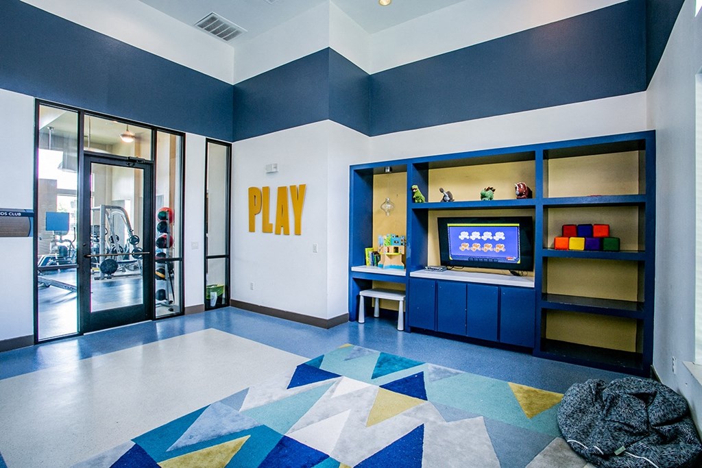 a recreation room with a tv and a desk with a chair
