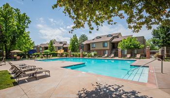 A large swimming pool surrounded by lounge chairs and umbrellas.