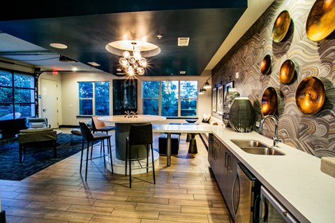 a dining room with a table and chairs and a kitchen with a sink