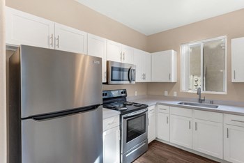 Stainless steel appliances and white painted cabinets in apartment kitchen Las Vegas - Photo Gallery 6