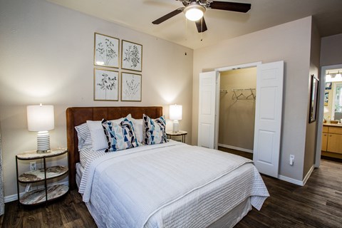 A bedroom with a large bed and a ceiling fan.