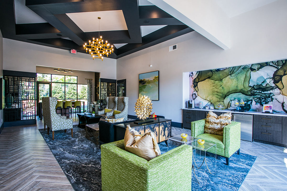 a living room with green furniture and a large painting on the wall