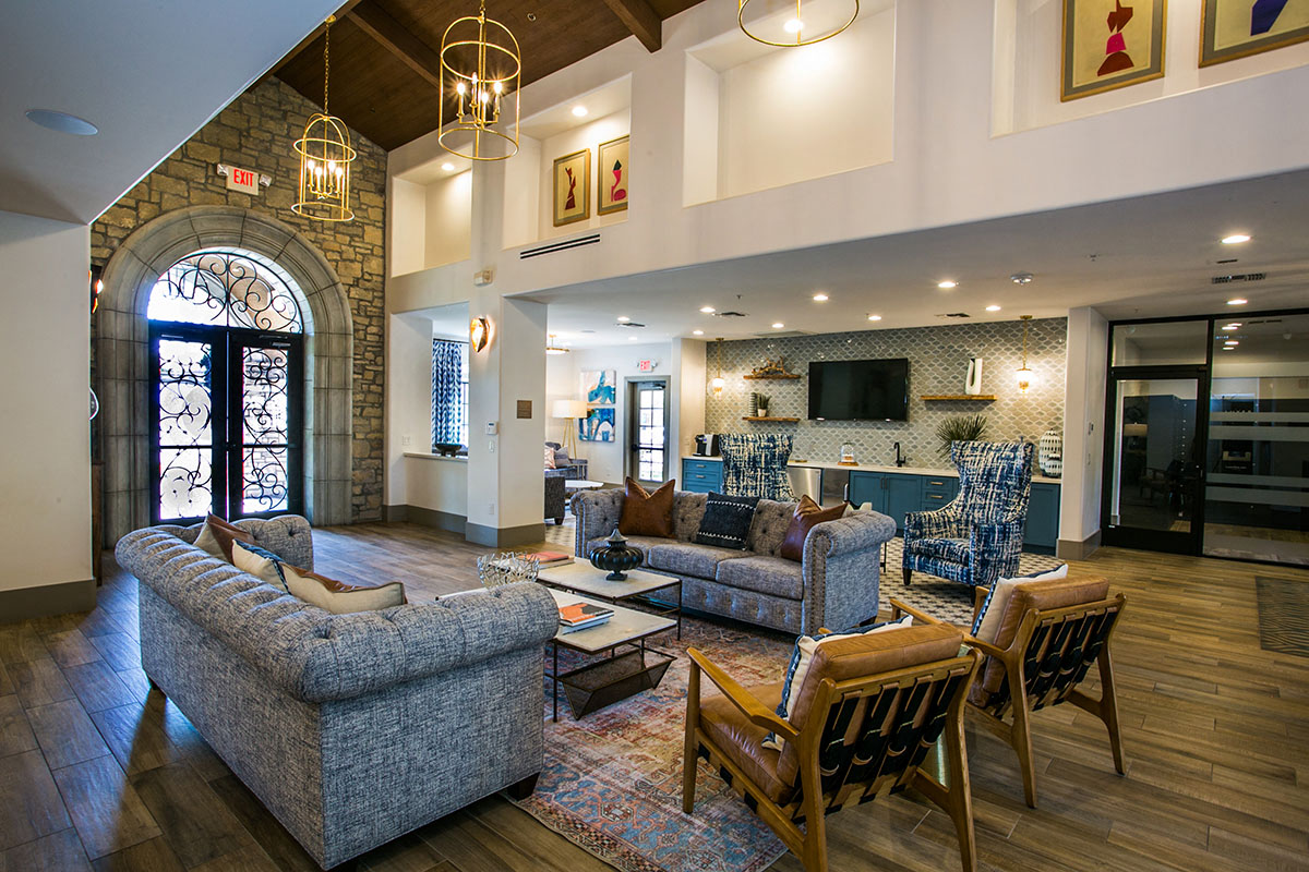 a living room with couches and chairs and a kitchen