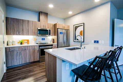 a kitchen with a white counter top and a sink