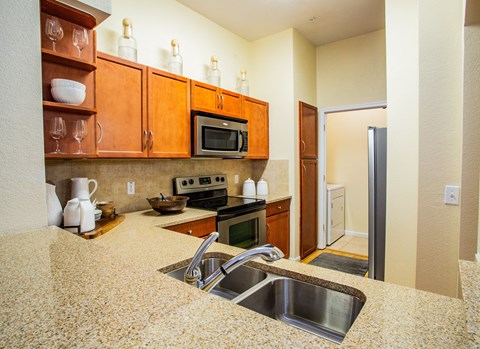 A kitchen with a sink and a microwave.