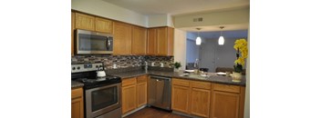 A kitchen with wooden cabinets and a black stove top.
