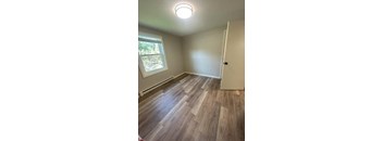 A room with a wooden floor and a window.
