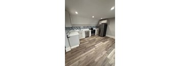 A kitchen with a refrigerator, oven, and sink.