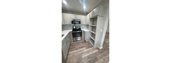 A kitchen with a stove top oven and microwave.