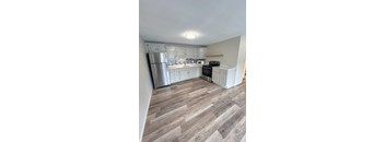 A kitchen with a refrigerator, oven, and microwave.