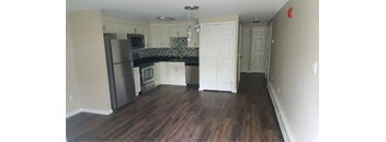 A kitchen with a refrigerator, microwave, oven, and cabinets.