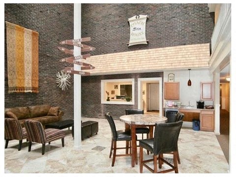 A dining room with a table set for six and a couch.
