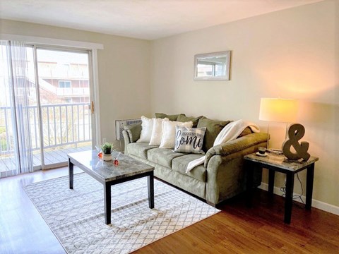 A living room with a couch, coffee table, and lamp.