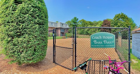 A sign that says Coach House is on a fence.