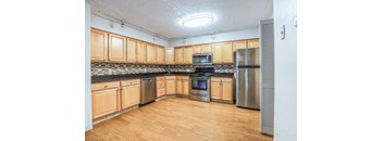 A kitchen with wooden cabinets and stainless steel appliances.