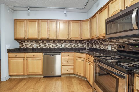 A kitchen with wooden cabinets and a black countertop.