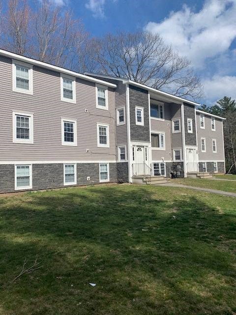 A large apartment complex with a grassy area in front.