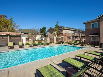 Pet-Friendly Apartments in Orcutt, CA- Knollwood Meadows- Sparkling Pool with Sun Lounge Chairs and Exterior Building View - Photo Gallery 10