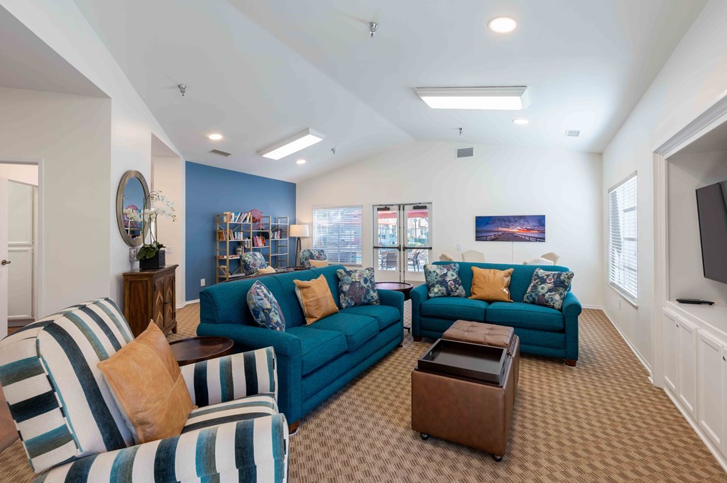 Dog-Friendly Senior Apartments in Ventura, CA - Cypress Meadows - Residential Lounge with High Ceilings, Bookshelves, and Blue Furniture