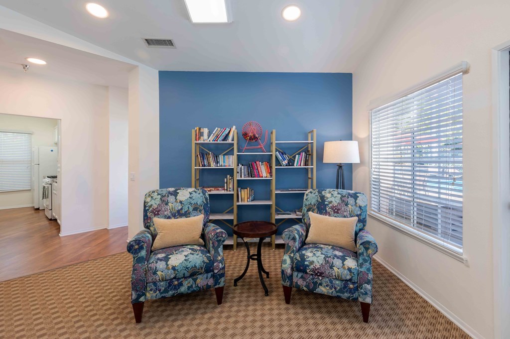 a living room with two chairs and a book shelf
