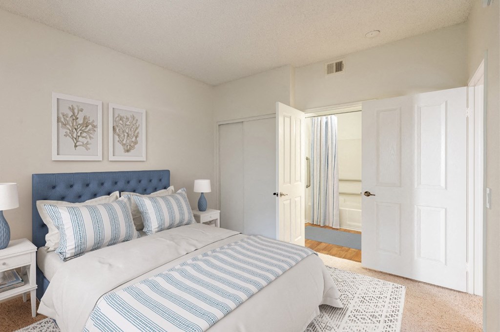 Retirement Homes in Ventura, CA - Cypress Meadows - Bedroom with Closet Sliding Doors, Connected Bathroom, and Blue Decorative Bedding