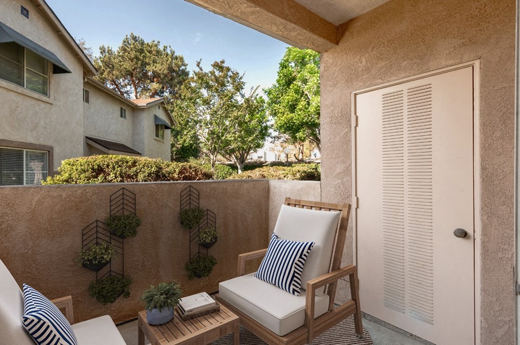 a small balcony with two chairs and a door