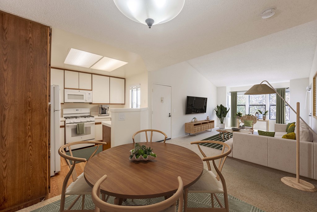A modern kitchen with a dining table and chairs in the foreground.