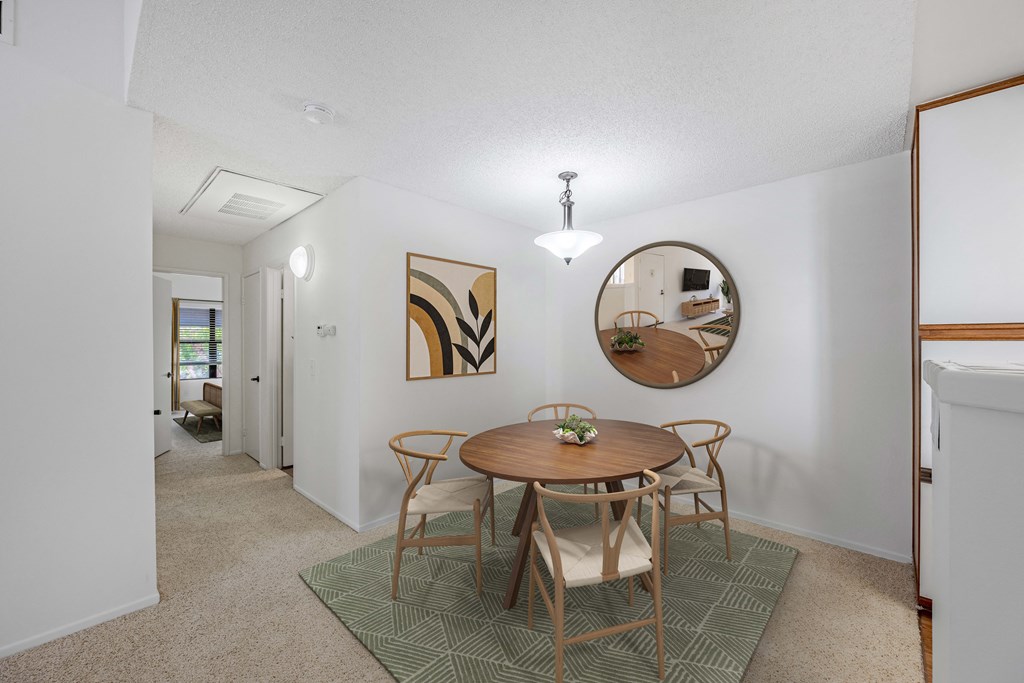 A dining room with a round table and chairs.