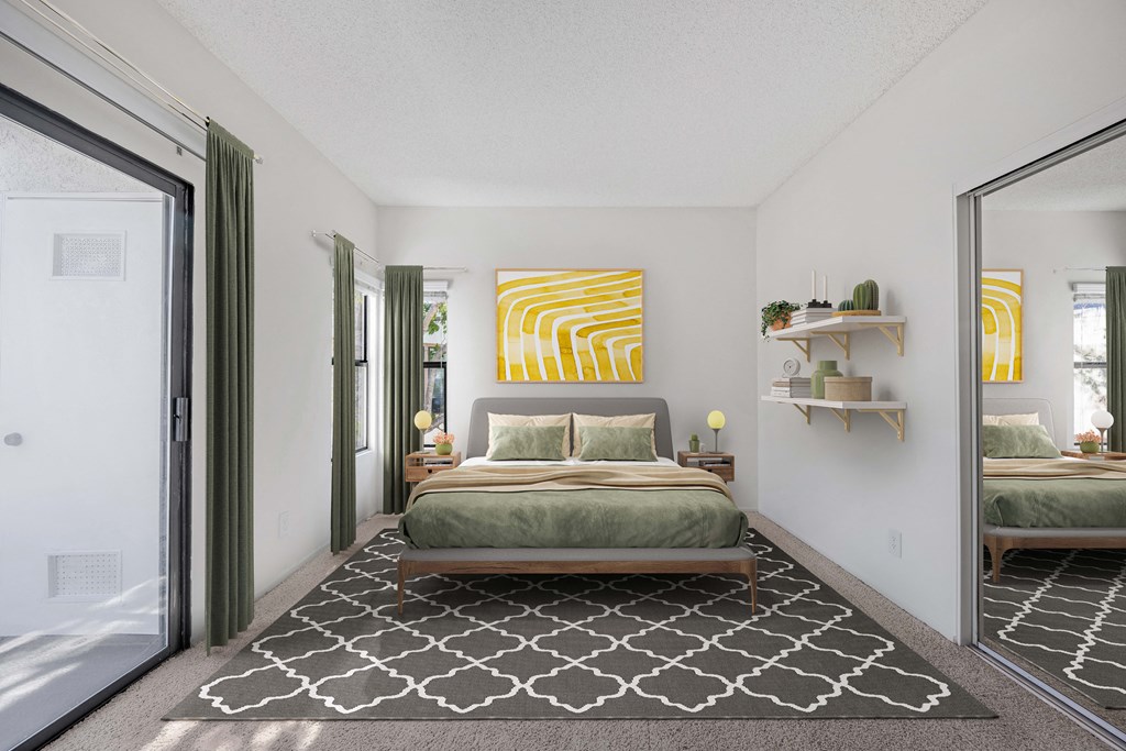 A bedroom with a bed, a rug, and a mirror.