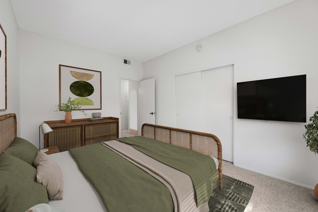 A bedroom with a bed, nightstand, and a painting on the wall.